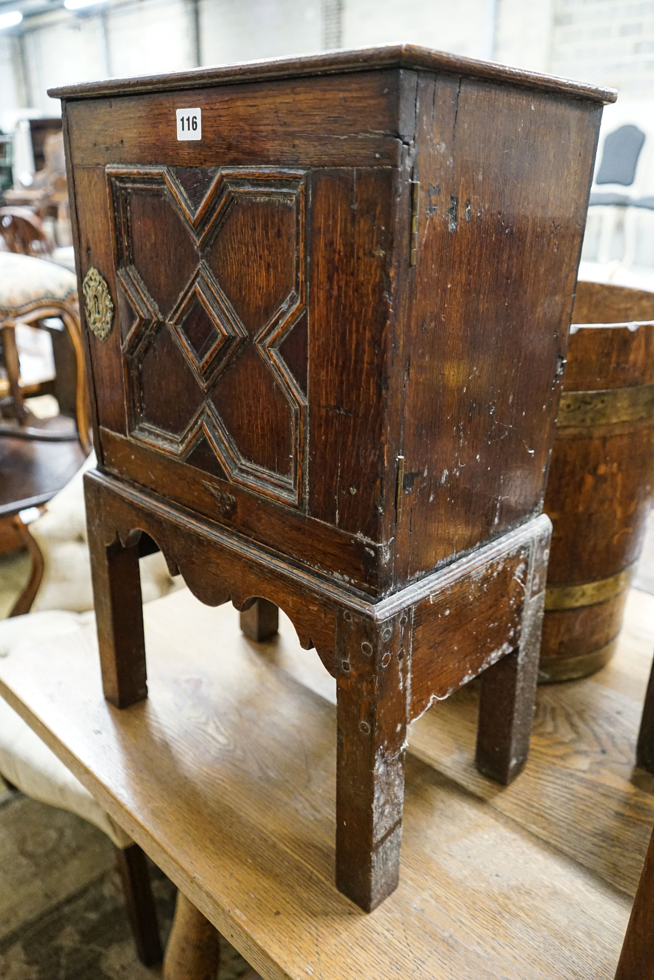 A late 17th century oak spice cupboard, with geometric panelled door enclosing five small drawers, on later stand, width 43cm, depth 27cm, height 67cm